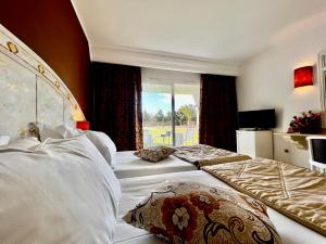ケリビアにあるCap Bon Kelibia Beach Hotel & Spaのベッド2台と窓が備わるホテルルームです。