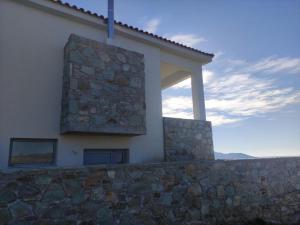 a building with a stone wall next to a building at Merabello Villas Karystos in Karistos