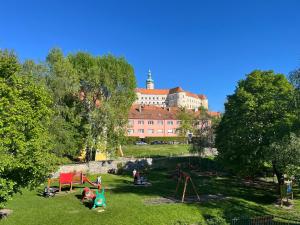 a group of children playing in a park in front of a building at Chateau view apartment Mikulov in Mikulov +4 photos