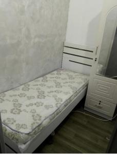 ドバイにあるBackpackers Hostelのドレッサーの横の部屋の小さなベッド1台
