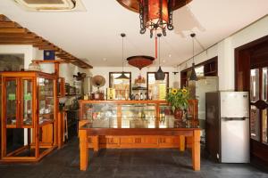 eine Küche mit einem Tisch und einem Kühlschrank in der Unterkunft Trúc Huy Tranquil Villa in Hoi An