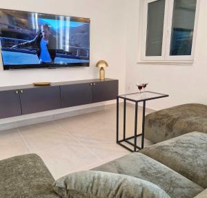 ein Wohnzimmer mit einem Flachbildfernseher an der Wand in der Unterkunft Holiday Home Nino with amazing swimming pool in Slatine