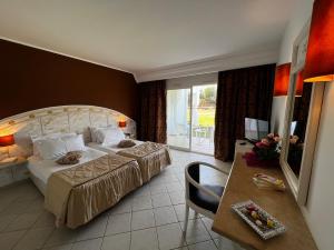 ケリビアにあるCap Bon Kelibia Beach Hotel & Spaのベッドとテーブルが備わるホテルルームです。
