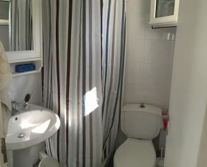 a bathroom with a white toilet and a sink at Summer Family House with sea view and garden in Kriopigi