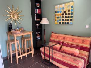 een woonkamer met een bank en een tafel bij Le Studio de Vasconia in Muret