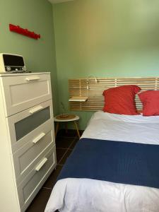 a bedroom with a bed and a dresser at Le Studio de Vasconia in Muret