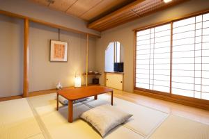 a living room with a table and a large window at Ryokan Asakusa Shigetsu in Tokyo