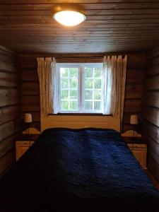 Un dormitorio con una cama azul y una ventana en Flott fjellhytte ned fantastisk utsikt., 