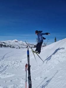 una persona saltando al aire en esquís en la nieve en Flott fjellhytte ned fantastisk utsikt., 
