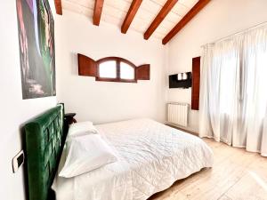 um quarto branco com uma cama e uma janela em Apartments MADEJ 3 em Bari Sardo
