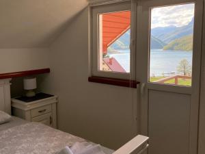 a bedroom with a window with a view of the water at Apartment LAKEVIEW in Pluzine