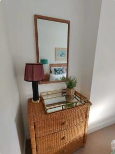 a mirror on top of a wicker table with a lamp at No 1A Penlee in Penzance