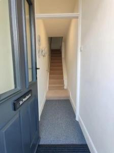 a hallway with a blue door and a staircase at No 1A Penlee in Penzance