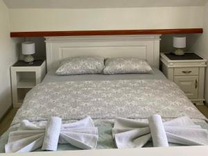 łóżko z 2 poduszkami i ręcznikami w obiekcie Apartment LAKEVIEW w mieście Plužine