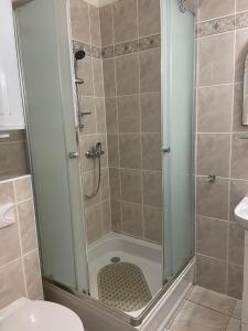 een douche met een glazen deur in de badkamer bij Mieszkanie przy promenadzie Trzęsacz in Trzęsacz