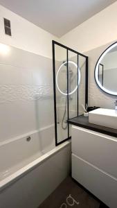 Un baño blanco con lavabo y espejo. en Superbe Appartement 2 chambres avec vue sur la mer et la montagne, en Marsella