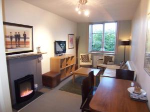 a living room with a fireplace and a dining room at Bagshaw Hall in Bakewell