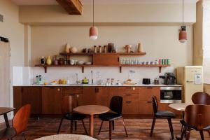 a kitchen with wooden cabinets and tables and chairs at Frenchdoor Orléans Cloître in Orléans