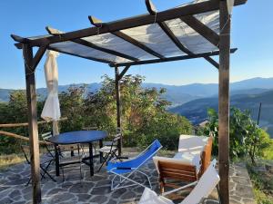 patio con mesa, sillas y vistas en Il Mandorlo, en Borgo Val di Taro