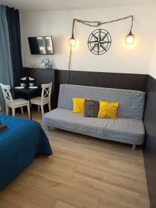 1 dormitorio con sofá azul y almohadas amarillas en Good Night in Szczecin en Szczecin