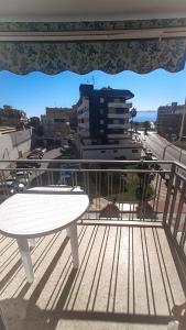 un tavolo bianco seduto sopra un balcone di Apartamento sencillo Cerca del mar . a Cullera