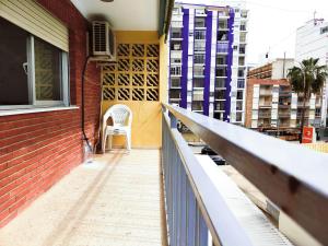 a white chair sitting on the balcony of a building at Apartamento sencillo Cerca del mar . in Cullera