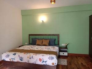 a bedroom with a bed with a green wall at The Black Stone in Munnar