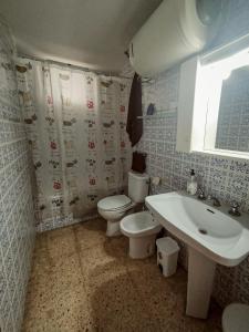 a bathroom with a toilet and a sink at Apartamento sencillo Cerca del mar . in Cullera