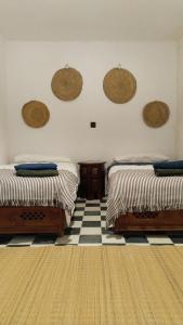 ein Schlafzimmer mit 2 Betten und einem karierten Boden in der Unterkunft Dar Gara in Tangier