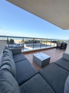 Aqua Mare Luxury Apartments في باراليا كاتيرينّيس: غرفة معيشة مع أريكة وإطلالة على المحيط