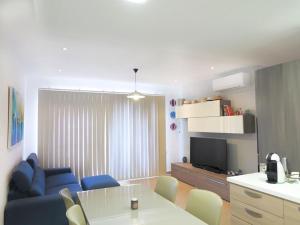 a living room with a blue couch and a table at Seaside Serenity: Mellieha Gem in Mellieħa