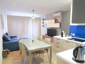 a kitchen and living room with a white table and chairs at Seaside Serenity: Mellieha Gem in Mellieħa