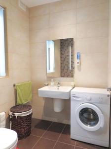 a bathroom with a washing machine and a sink at Seaside Serenity: Mellieha Gem in Mellieħa