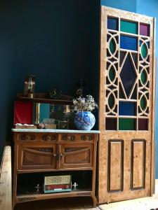 a wooden cabinet with a mirror in a room at VASILIKON Hotel 1888 the past is present in Kalamata