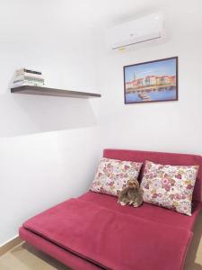 a purple couch with two pillows and a teddy bear on it at Seaside Serenity: Mellieha Gem in Mellieħa