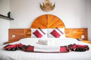 uma cama com toalhas vermelhas e brancas em Sky View Hotel Buriram em Buri Ram