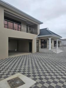 a house with a checkered floor and a balcony at Ubuntu Guesthouse in East London