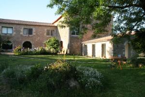 una casa con un cortile con un tavolo nell'erba di Mas des Clauzals a Le Cros
