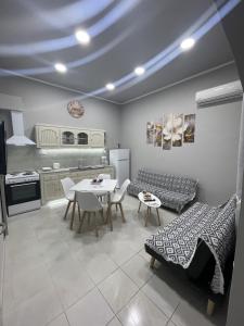 Meraki house of kalymnos Apartments في كاليمنوس: غرفة معيشة مع طاولة ومطبخ