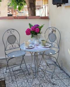 a table with two chairs and a vase of flowers at Casa Vacanze Susanna in Monfalcone +18 photos