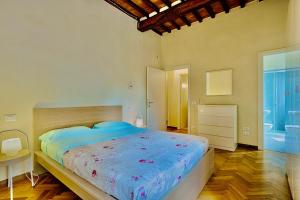 a bedroom with a large bed with a blue comforter at Borgo di Libbiano in Libbiano