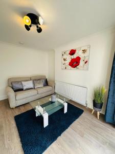 a living room with a couch and a table at Deluxe Bungalow in Longham