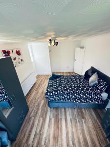 a bedroom with a bed and a wooden floor at Deluxe Bungalow in Longham