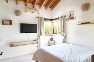 a bedroom with a bed and a tv on the wall at Villa Helda - Private Bedroom in a Shared Villa of 4 bedroom in Villaverde