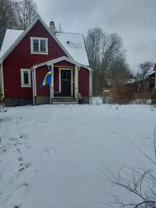 a red house with a flag on it in the snow at Elanden rust in Edebäck
