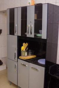 a kitchen with white cabinets and black counter top at Itawa Apartments in Ndola