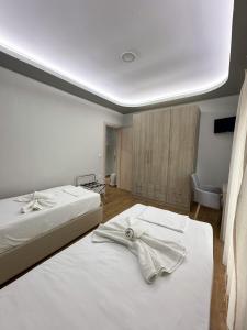 a bedroom with two beds with white sheets at Aqua Mare Luxury Apartments in Paralia Katerinis