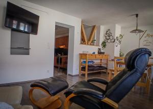 a living room with two leather chairs and a table at Gemütliche Wohnung 80qm - viele Ausflugsziele in Vöhrenbach