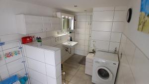 a white bathroom with a washing machine and a sink at Gemütliche Wohnung 80qm - viele Ausflugsziele in Vöhrenbach