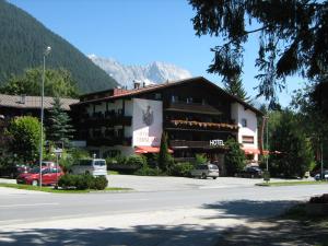 ein Gebäude an der Seite einer Straße mit einem Berg in der Unterkunft Landhaus Bergland in Obsteig